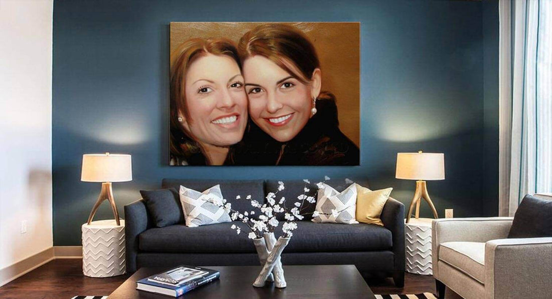 Twee lachende vrouwen in een portret boven een grijze bank met kussens, geflankeerd door witte tafels en lampen; moderne kunst in een elegante woonkamer.