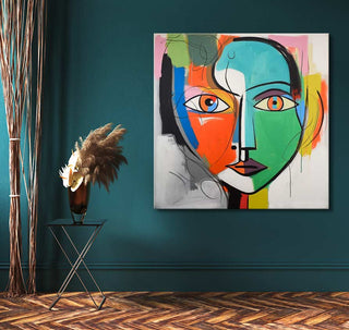 Corneille signature - Audrey Hepburn abstract painting on teal wall, featuring bold colors and cubist style. Displayed with black metal table and pampas vase.