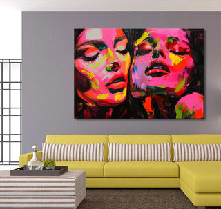 Françoise Nielly-signature - Pink Twins painting above bright yellow sofa in modern living room, showcasing two abstract female faces with expressive, vivid colors.