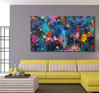 Abstract canvas Night Flowers by Jackson Pollock, vibrant drip-smear style, above mustard sofa with striped pillows and ottoman, in modern living-room setting.