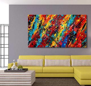 Abstract painting Wild Dreams with vibrant colors by Jackson Pollock, featured above a yellow sectional sofa in a modern living room setting.
