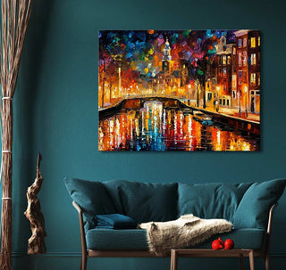 Handgeschilderd schilderij 'Prinsengracht' in de stijl van Leonid Afremov, olieverf op canvas, met kleurrijk stadsaanzicht boven een teal bank in een moderne woonkamer.