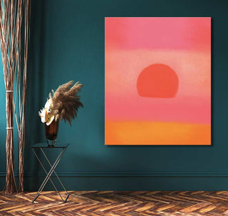 Andy Warhol signature 'Sunset' painting with warm bands and sun motif, set against a teal wall. Features pampas grass in a dark vase on a side table.