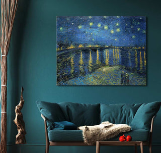 Vincent van Gogh - Sterrenacht over de Rhône (110x85cm) framed oil painting above a teal sofa, surrounded by cozy decor and driftwood sculpture.