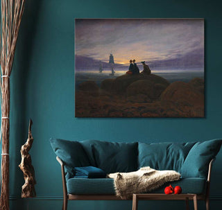 Caspar David Friedrich's Mondaufgang am Meer painting, depicting three figures on a rocky shore at dusk, mounted on a teal wall above a matching sofa.