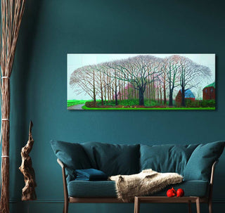 David Hockney's Bigger Trees Near Warter painting above a teal sofa, showcasing a modern impressionist landscape with winter trees and buildings.