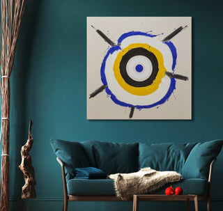 Kenneth Noland's Abstract Face painting with concentric circles in a stylish interior, featuring a teal loveseat, decorative twigs, and a side table with red spheres.
