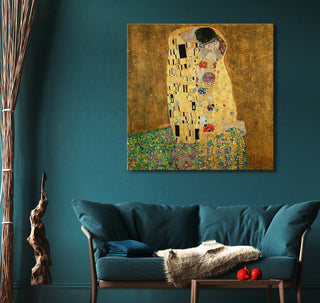 Gustav Klimt's De Kus (vierkant) painting on teal wall above a cozy teal sofa, styled with fur throw and cushion, creating a warm, artful living space.