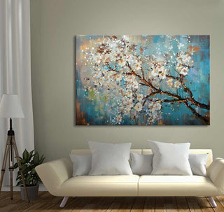 Pluimbloesem - Olieverf op canvas: Handgeschilderd doek met witte bloesem op takken tegen een teal en ochre achtergrond, boven een moderne crèmekleurige bank geplaatst.