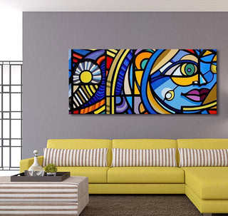 Picasso signature 'La Vie' painting, cubist-style with sun and face motifs, adorns a modern living room with a yellow sofa and matching ottoman as coffee table.