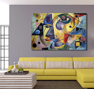 Picasso signature - Day Dreams, a vibrant abstract canvas with geometric faces, adorns a gray wall above a yellow L-shaped sofa in a modern living room.