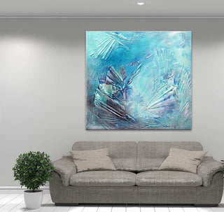 Blue Ocean - Dikke olieverf op canvas in een moderne woonkamer met een lichtgrijze bank en plant. Abstracte blauwe tinten sieren het kunstwerk boven de bank.