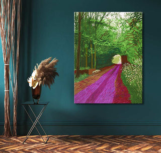 David Hockney's Arrival of Spring in Woldgate painting showcasing a vibrant tree-lined path, complemented by a black metal side table with pampas grass.