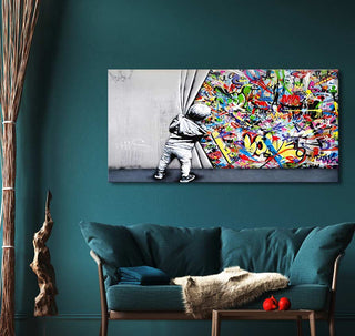 Banksy - Live like a Kid (75x37cm) features a child unveiling vibrant graffiti, adding dynamic street art flair to a modern living room.