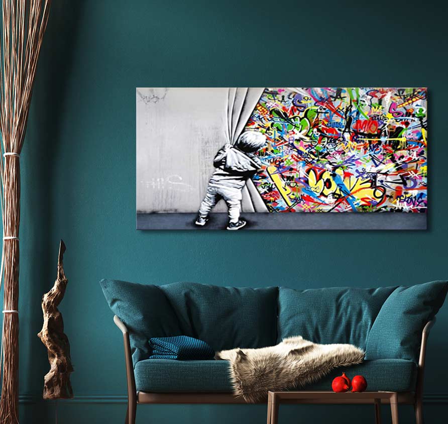 Banksy - Live like a Kid (75x37cm) features a child unveiling vibrant graffiti, adding dynamic street art flair to a modern living room.