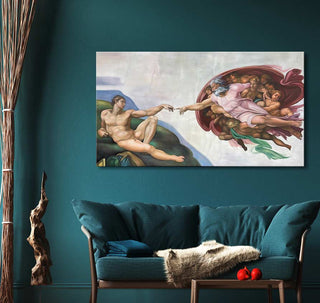 Michelangelo's The Creation of Adam canvas print on teal wall above teal sofa with throw pillows, driftwood, reeds, and pomegranates.
