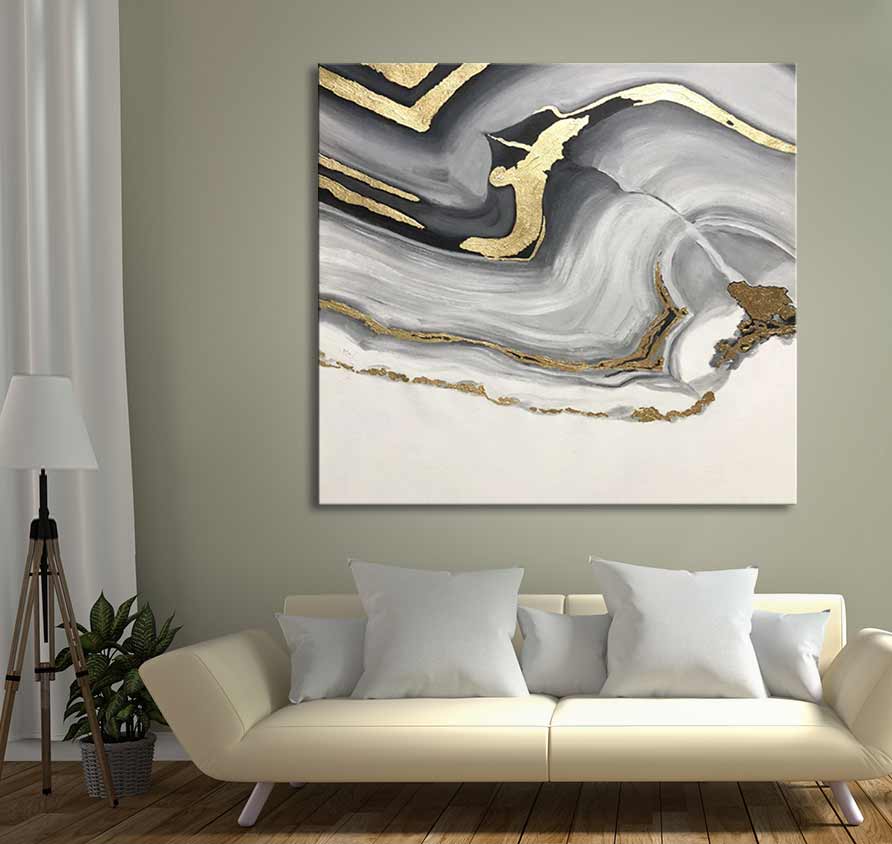 Gelaagd Goud 2 - Acrylverf op canvas: abstract schilderij met gouden accenten op grijs en wit, boven een crèmekleurige bank. Perfect voor modern interieurdesign.