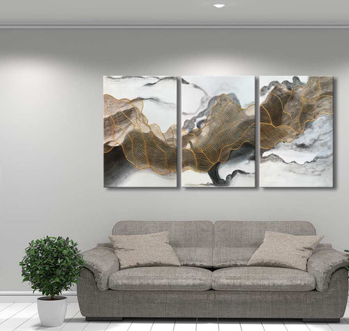 3-Luik Goudweb - Acrylverf op canvas: Drie-panelen schilderij met gouden lijnen op marmeren achtergrond, boven een grijze bank. Perfect voor moderne interieurs.