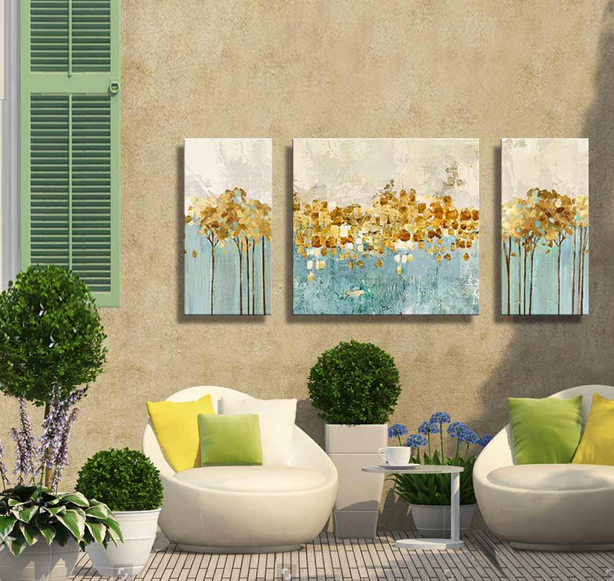 3-Luik Golden Trees - Acrylverf op canvas: Drie abstracte schilderijen met goudkleurige bladeren tegen een blauwe achtergrond, gemonteerd boven een moderne loungeopstelling met planten.